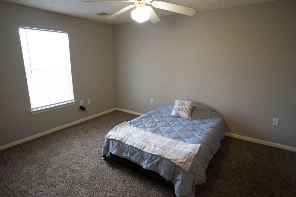 Well-lit bedroom with a ceiling fan at Hampton Chase in Palestine, Texas