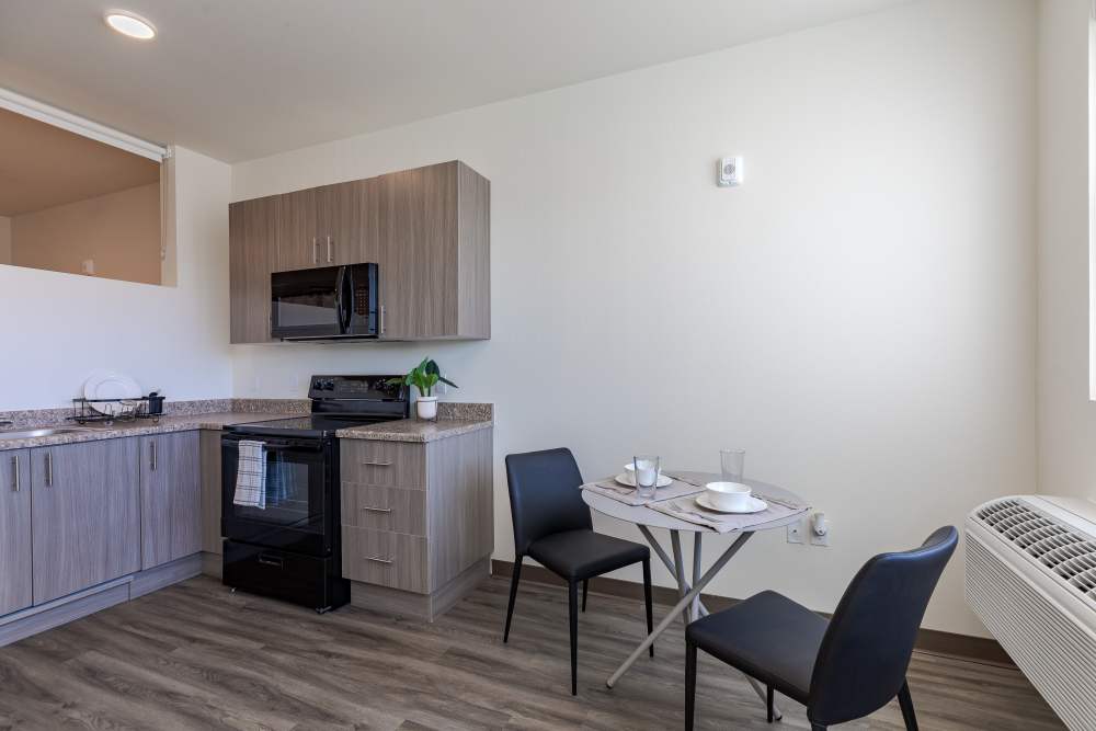 Kitchen with Black Appliances and Dining Area at Sable Station in Aurora, Colorado