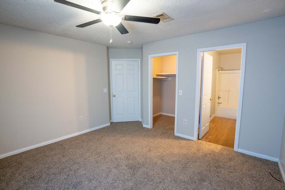 Unfurnished bedroom with attached bathroom and walk-in closet at Arrington Estates of West Memphis in West Memphis, Arkansas