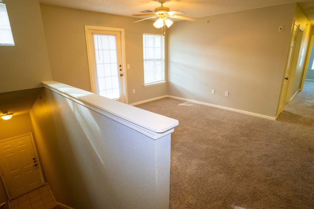 Living room with carpet flooring and stairs to down at Hampton Village in Palestine, Texas