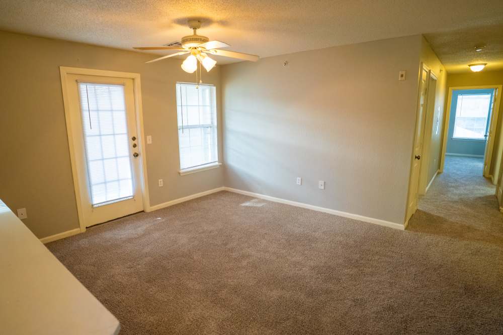 Living area with patio door and window at Hampton Village in Palestine, Texas