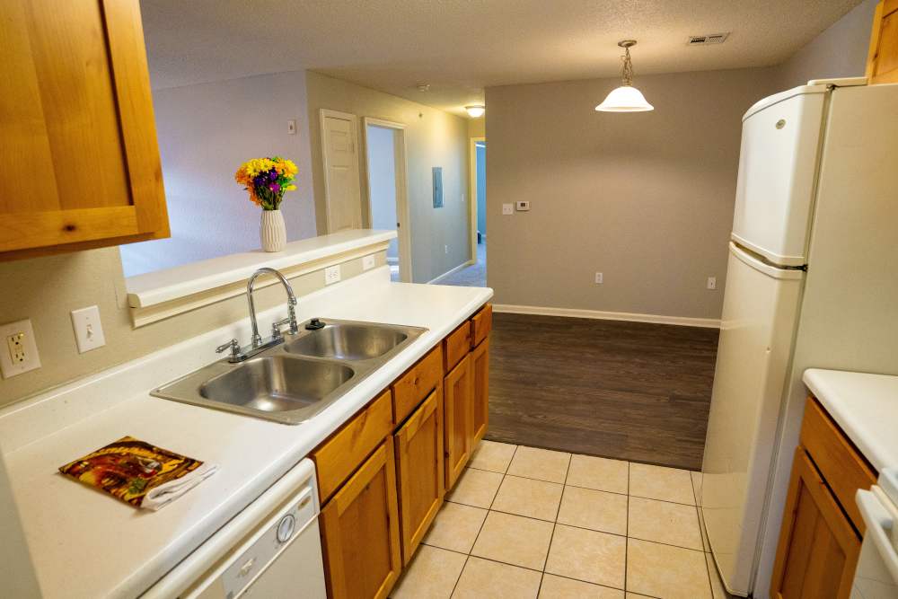 Kitchen with white appliances, tile flooring  and dining area at Hampton Village in Palestine, Texas