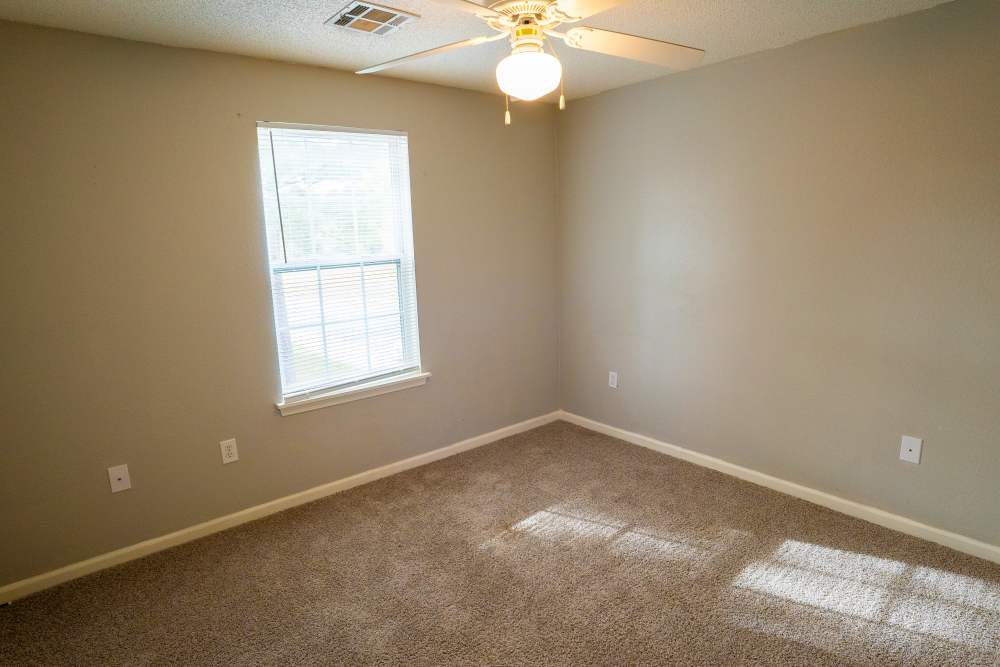 Bedroom with carpet flooring and window at Hampton Village in Palestine, Texas