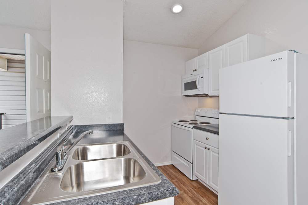 Kitchen with white appliances at Oakwood Condos Bedford in Bedford,Texas