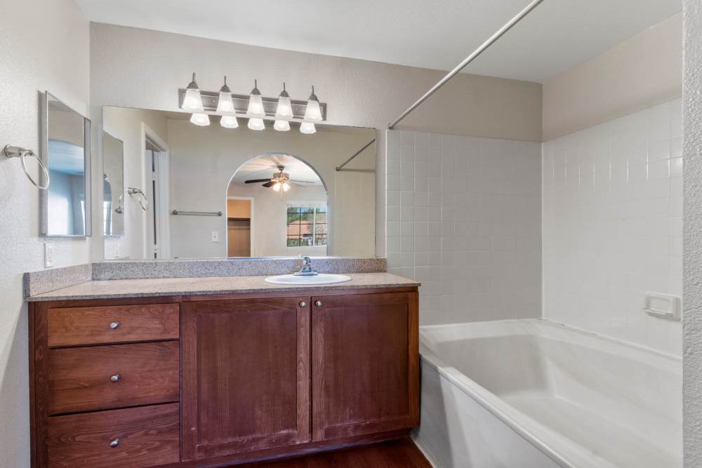 Bathroom vanity beside shower tub at Fairways on Green Valley in Henderson, Nevada