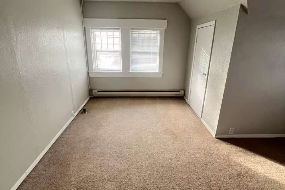 Bedroom area with window and carpet flooring at Westminster Apartments in Spokane, Washington