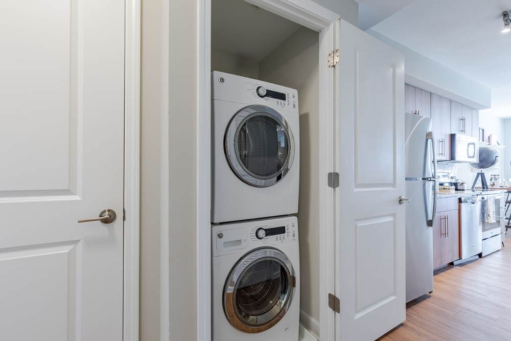 Stacked laundry machines in neat, modern utility space at Jefferson Marketplace in Washington D.C., District of Columbia