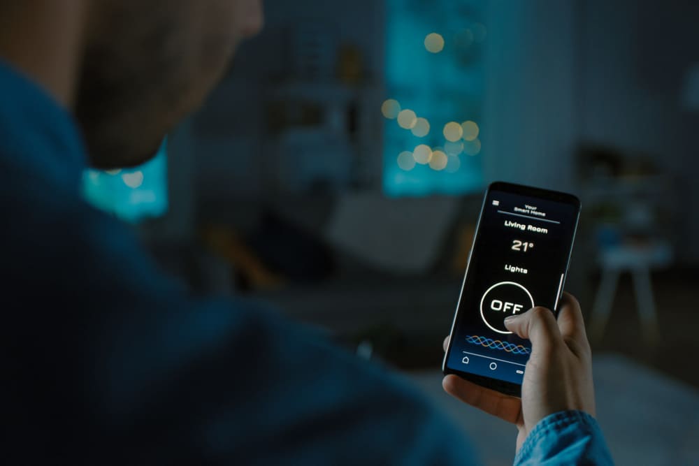 Resident checking thermostat with smart home technology at Hart Townes in Woodruff, 