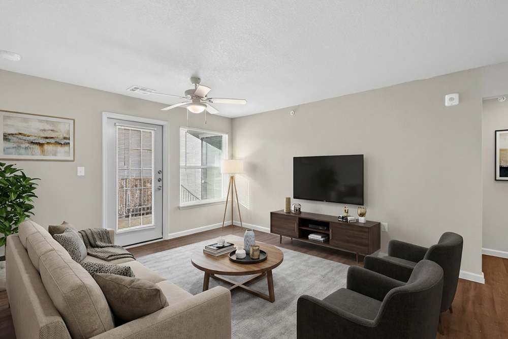 Living room with center table, patio french door and wall mount tv unit at Juniper Pointe in Kaufman, Texas