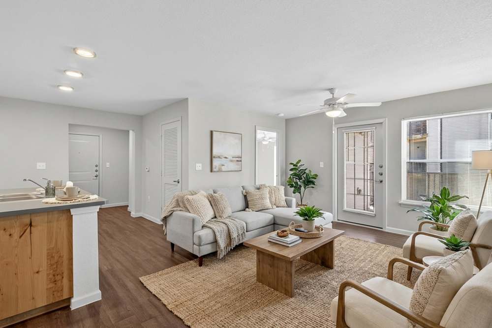 Open layout living room near kitchen with patio french door at Juniper Pointe in Kaufman, Texas