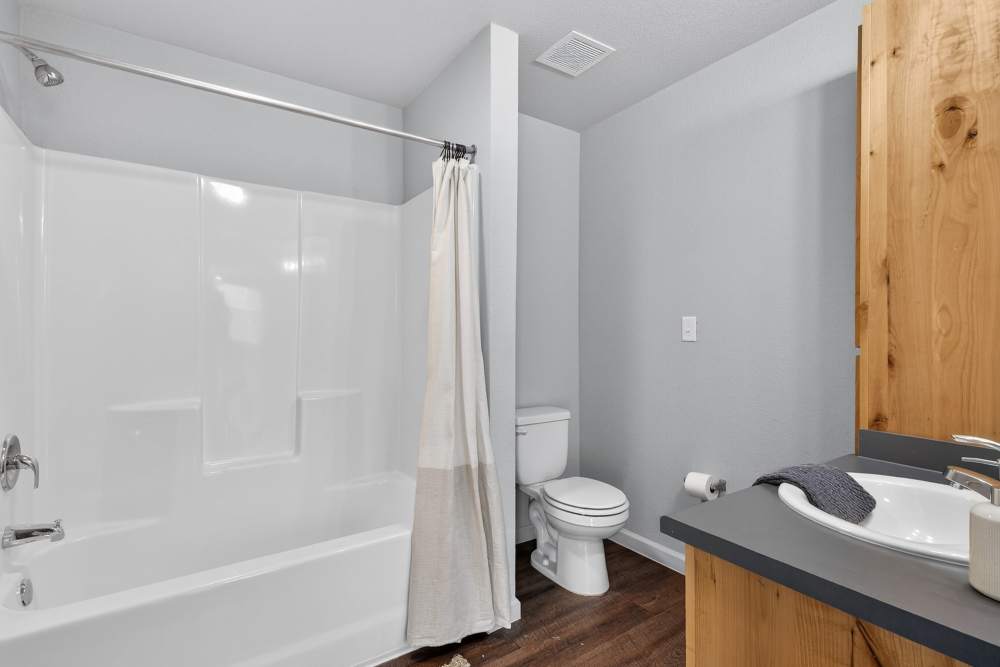 Bathroom with tub and commode at Juniper Pointe in Kaufman, Texas