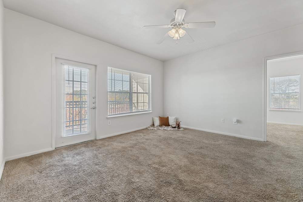 Carpeted room with door to a private balcony at Knightsbridge in Humble, Texas