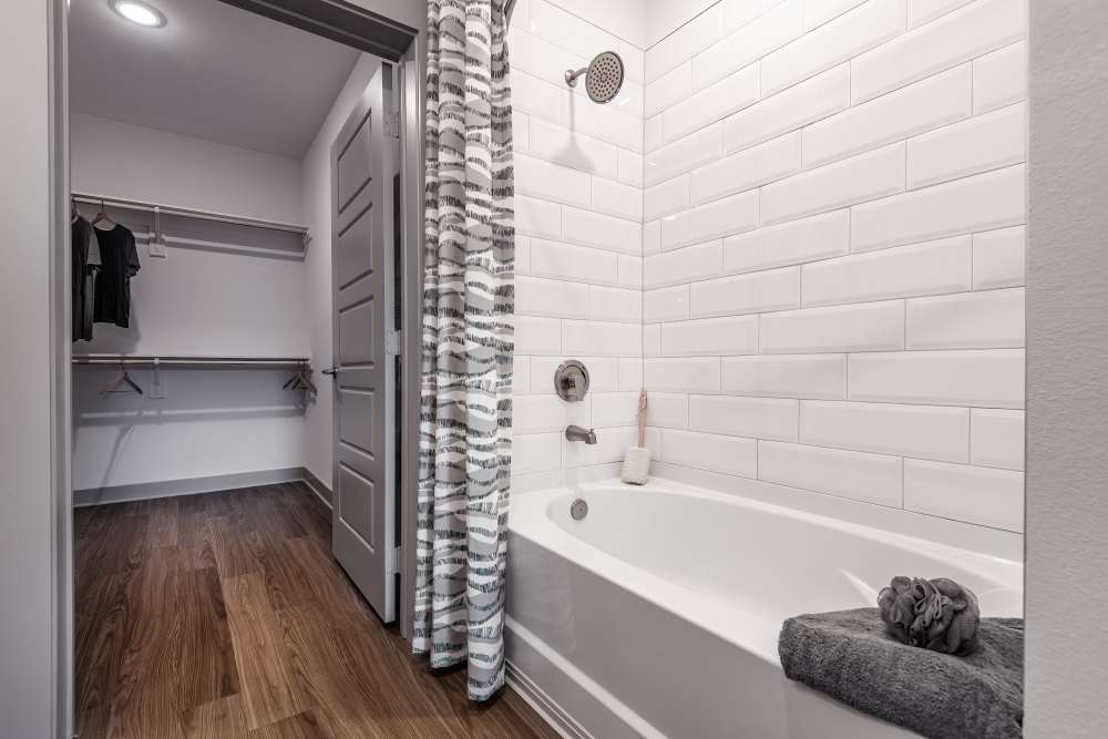 bathroom with tub leading into a walk in closet