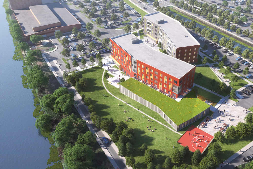 View of exterior of apartments and green lawn at Island Parkside in Lawrence, Massachusetts