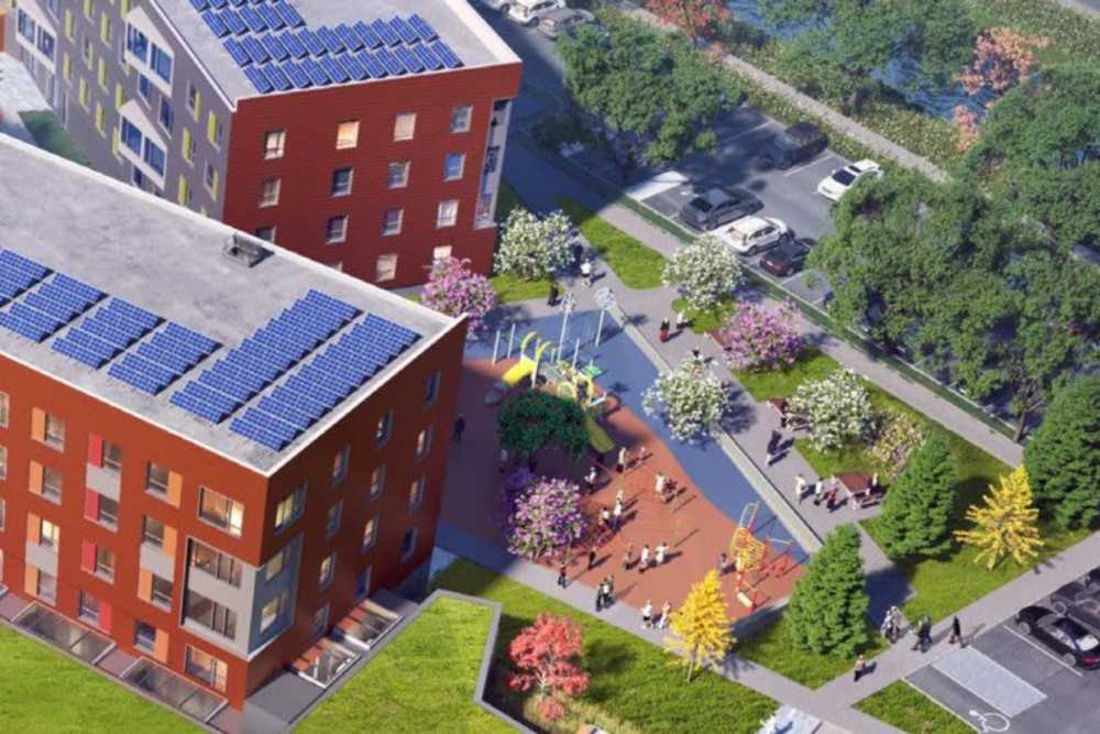 View of exterior of apartments and green lawn at Island Parkside in Lawrence, Massachusetts