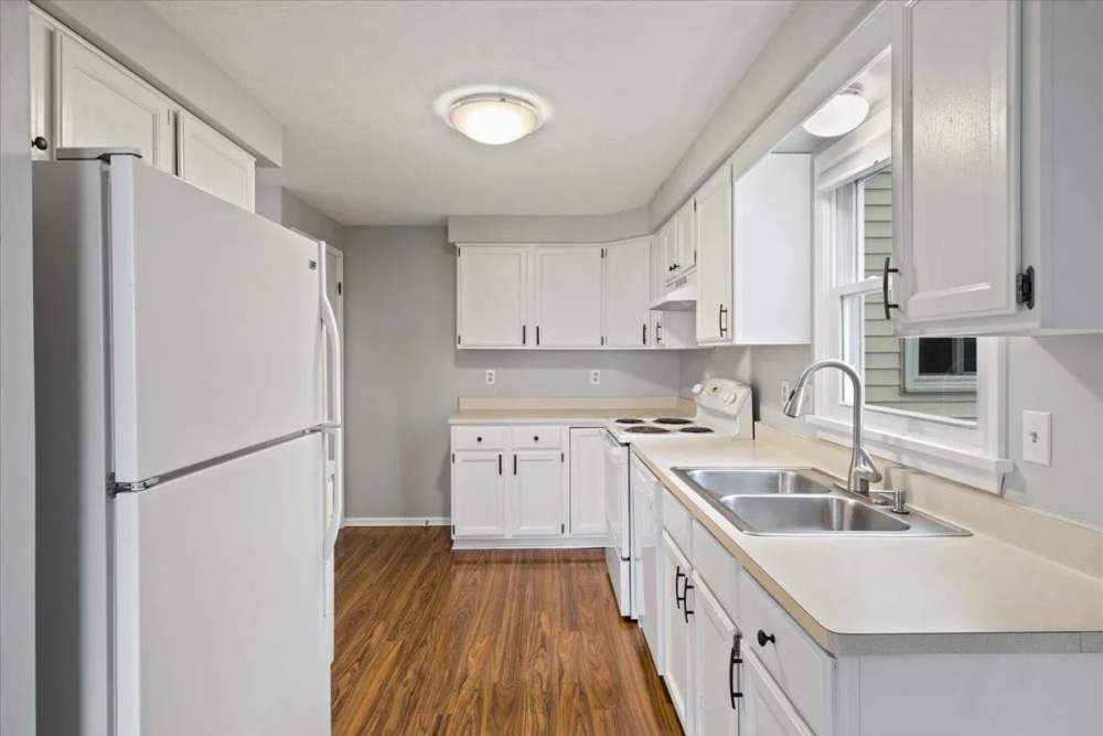 Kitchen with white appliances at Summit Knolls Apartments & Townhomes in Webster,New York