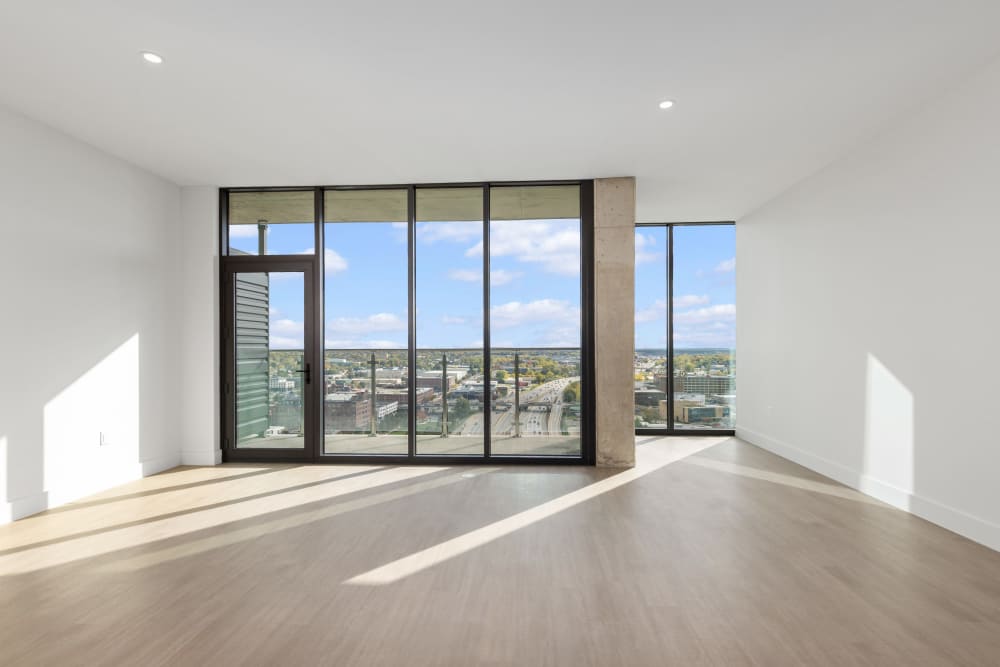 Living room with floor‑to‑ceiling windows and city skyline view at Studio Park Tower & Lofts in Grand Rapids, Michigan