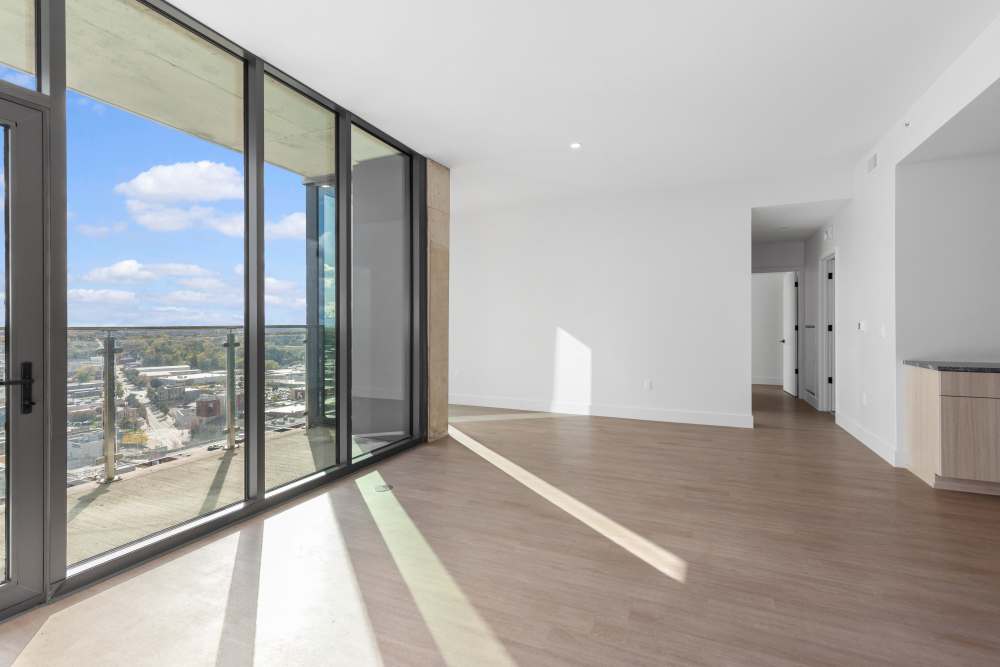 Living room with balcony access and expansive window views at Studio Park Tower & Lofts in Grand Rapids, Michigan