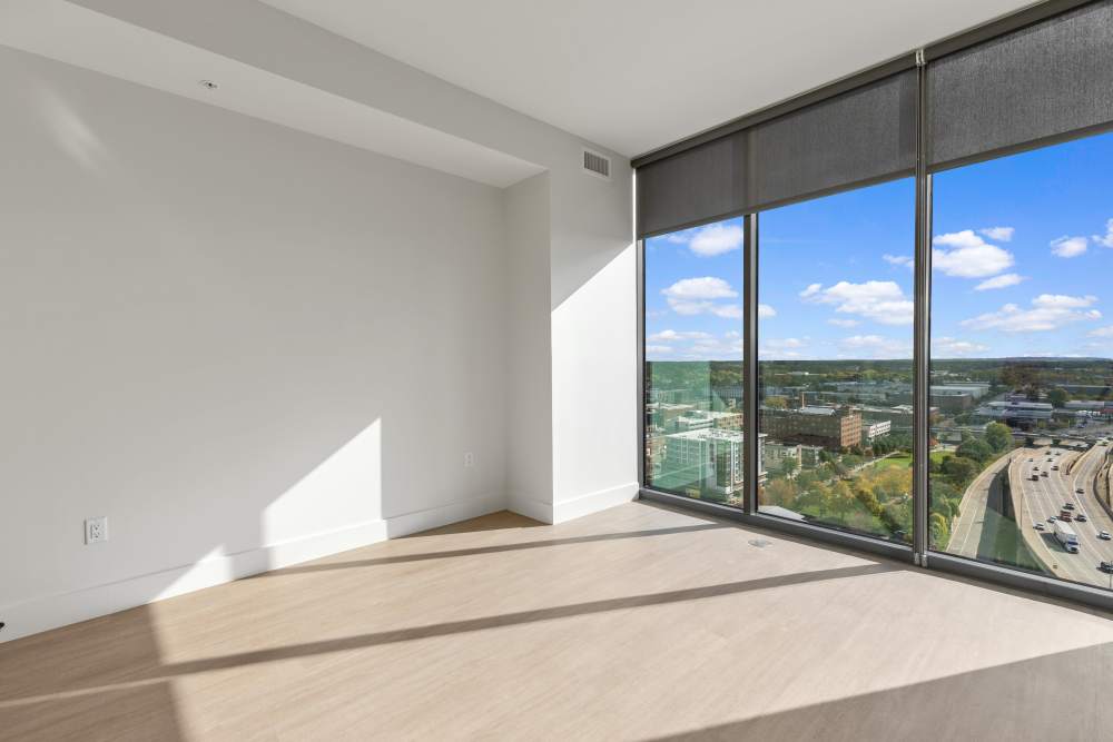 Bedroom with floor‑to‑ceiling windows and highway city views at Studio Park Tower & Lofts in Grand Rapids, Michigan