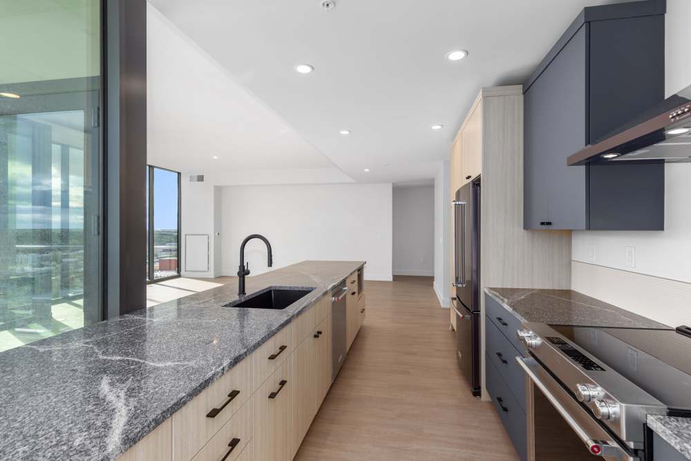 Galley kitchen with granite counters, black fixtures, and open layout at Studio Park Tower & Lofts in Grand Rapids, Michigan