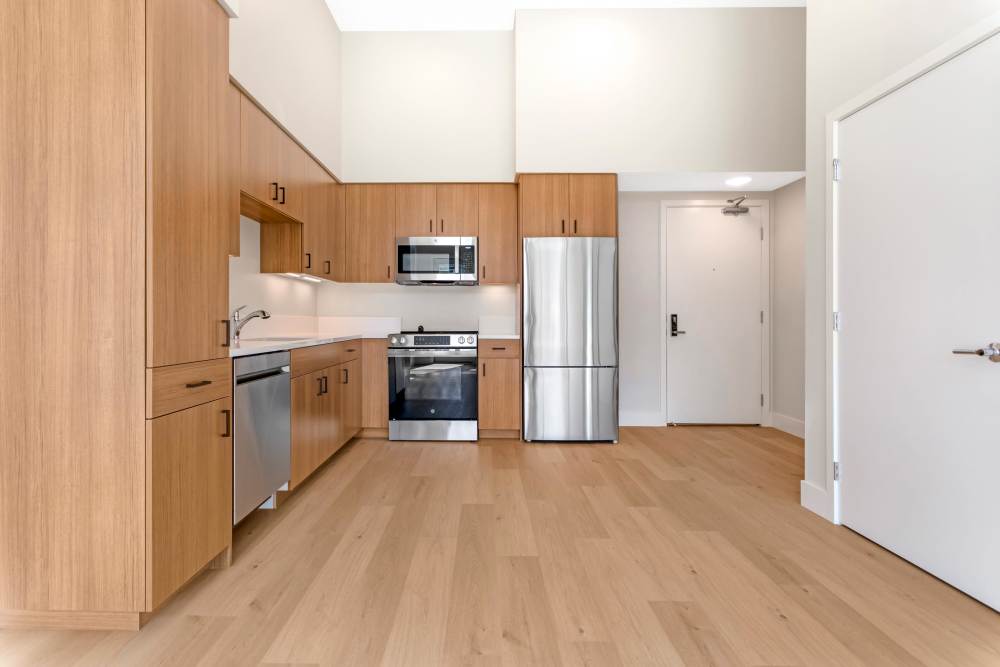 Kitchen and Dining Room at The Millton with wood style plank flooring and stainless steel appliances.
