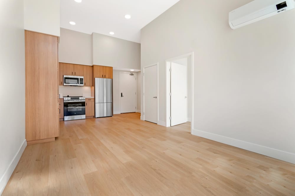 Kitchen and Dining/Living Room at The Millton with wood style plank flooring and stainless steel appliances.