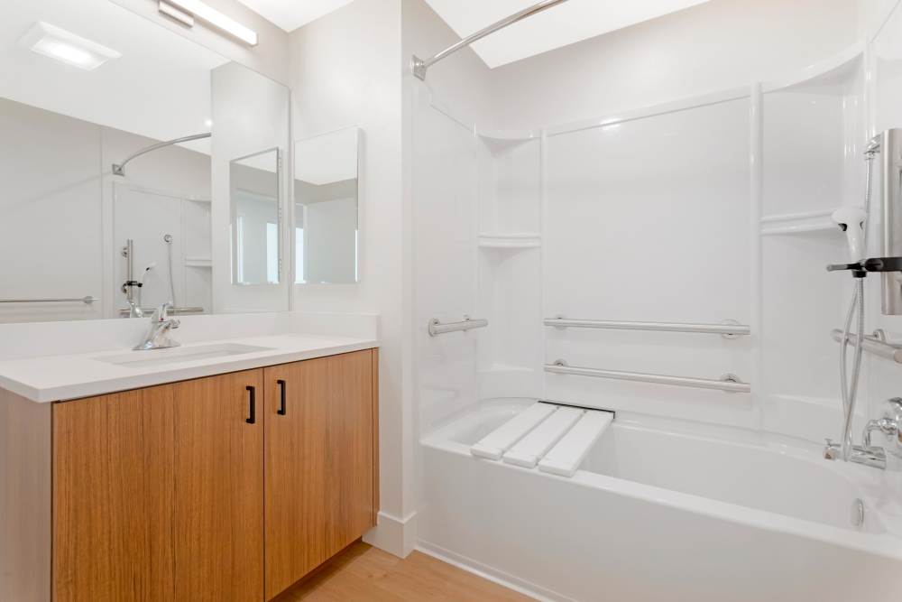 Bathroom at The Millton with wood style plank flooring shower and tub.
