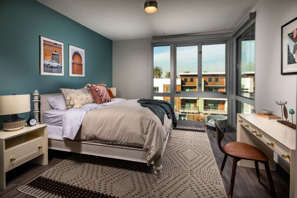 Bedroom with full height window at Haven Apartments in Los Angeles, California