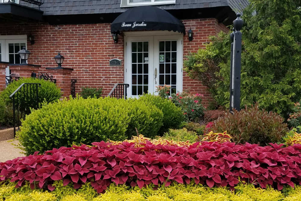 Entry to leasing office with color full landscaping at Beau Jardin Apartments in St. Louis, Missouri