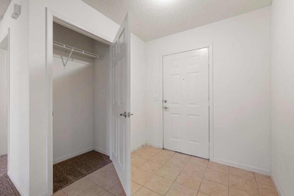 White front door, tiled floor, and open closet at Oaklawn II in Rogersville, Missouri 