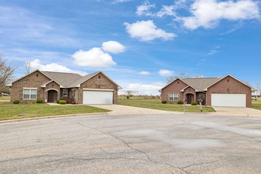 Exterior view of apartments with path leading to the entrance at Oaklawn Estates in Rogersville, Missouri
