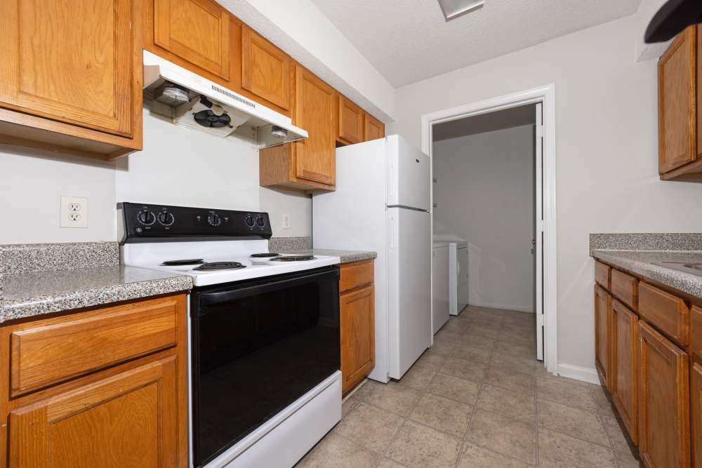 Kitchen with wood cabinets and white appliances at Livingston Oaks in Birmingham, Alabama
