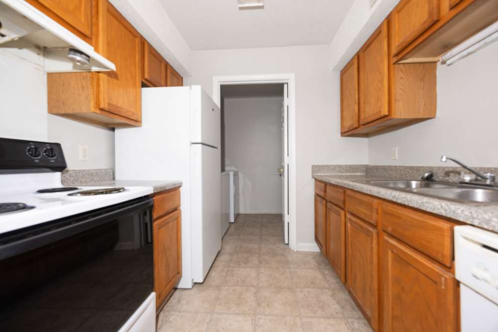 Kitchen with wood cabinets and access to laundry area at Livingston Oaks in Birmingham, Alabama