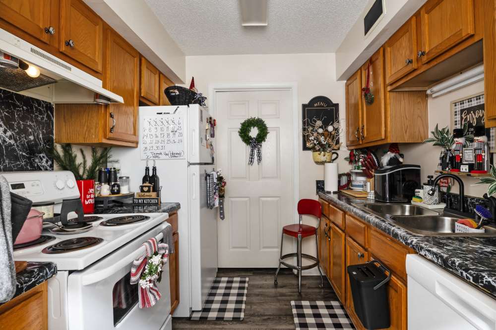 Kitchen with wooden cabinets, holiday decor, and black marble counters at Livingston Oaks in Birmingham, Alabama