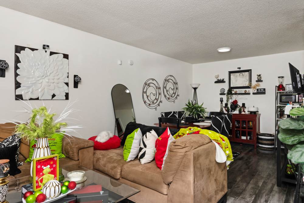 Living and dining space with brown sectional sofa, glass coffee table at Livingston Oaks in Birmingham, Alabama