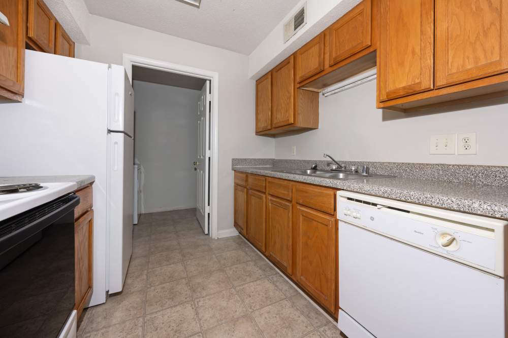 Kitchen with white appliances, double sink and access to laundry area at Livingston Oaks in Birmingham, Alabama