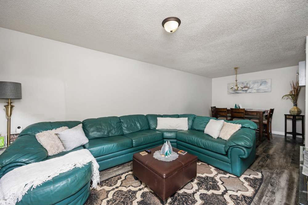 Living and dining area with green sectional sofa at Livingston Oaks in Birmingham, Alabama