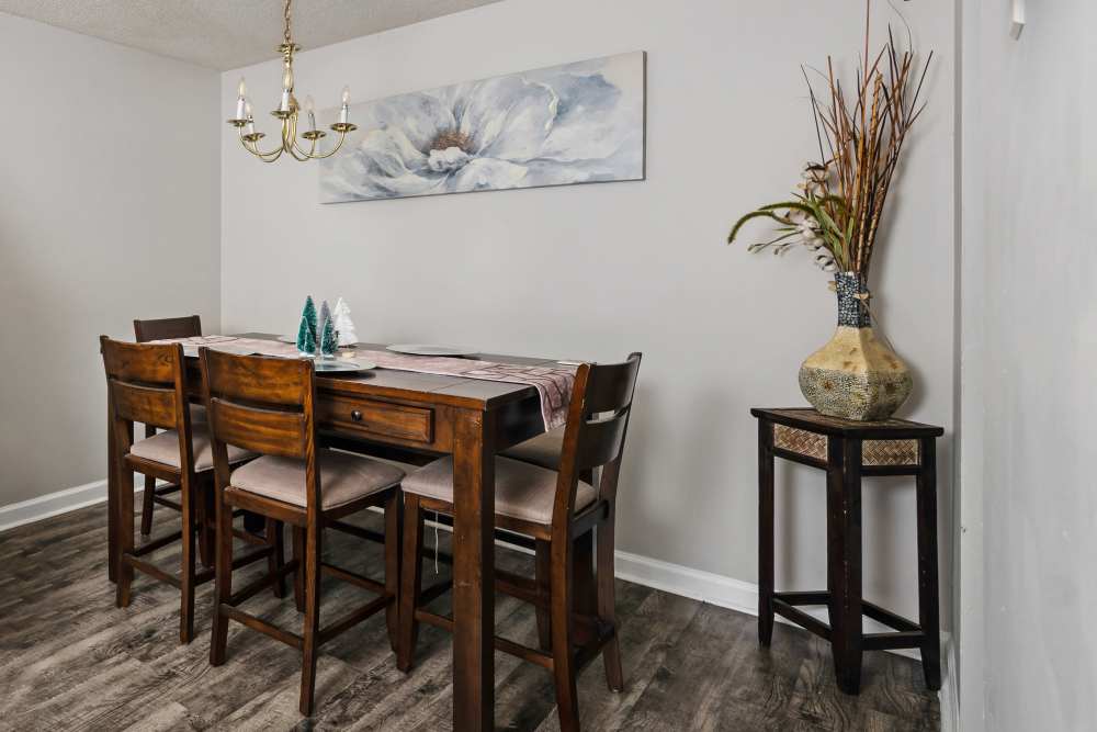 Dining area with wooden table, six chairs, chandelier at Livingston Oaks in Birmingham, Alabama