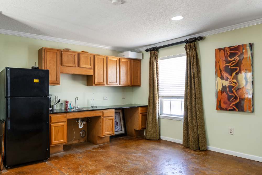 Kitchen with wood cabinets and black refrigerator at Livingston Oaks in Birmingham, Alabama 