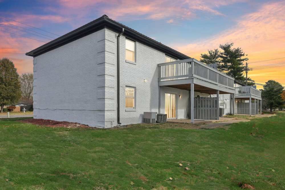 Side view apartment with with balconies, lawn, and sunset sky at Charleston Square Apartments in Columbus, Indiana