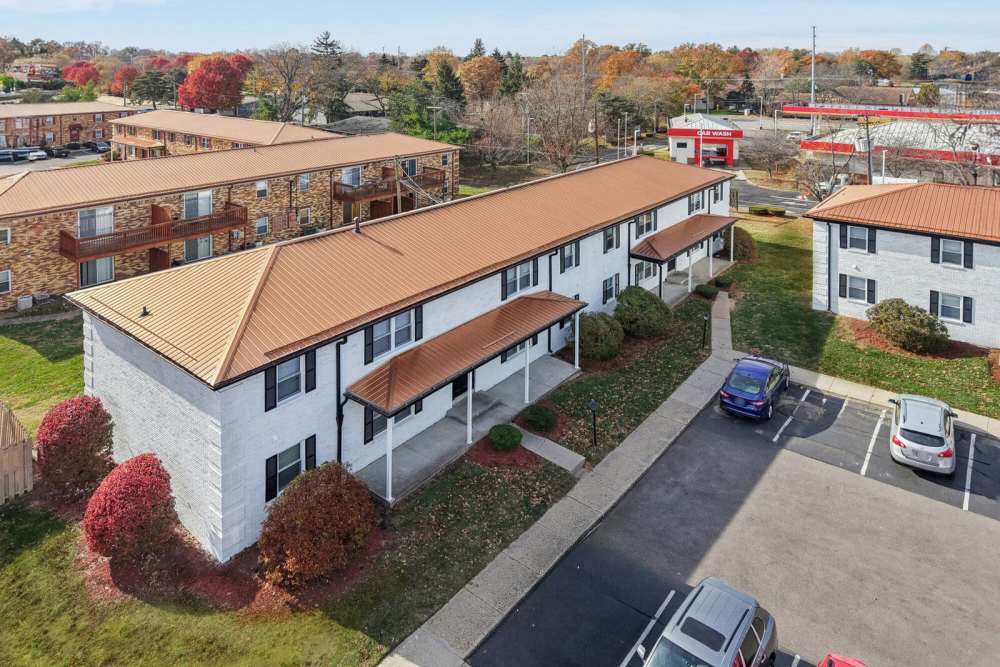 Apartment complex with parking lot, and autumn trees at Charleston Square Apartments in Columbus, Indiana