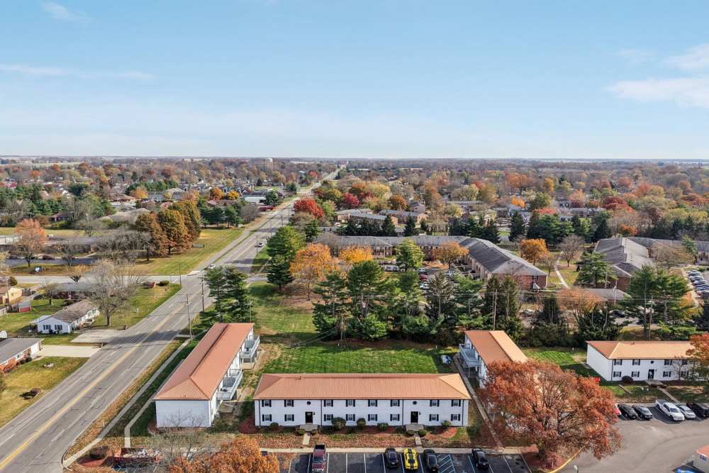 Beautiful aerial view of suburban apartments with parking lots, and autumn trees at Charleston Square Apartments in Columbus, Indiana