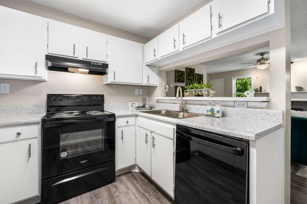 White cabinets and black appliances in an apartment kitchen at Renaissance at Galleria in Hoover, Alabama