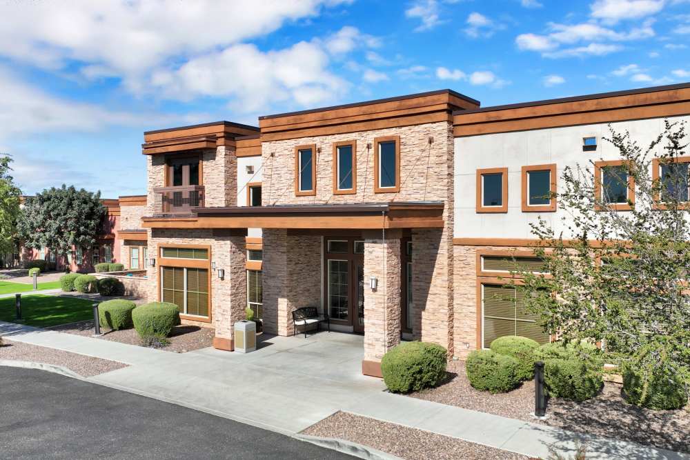 Front exterior of a modern stone‑and‑stucco building with landscaping, at Sky Vista in Mesa, Arizona