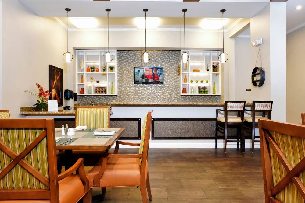 Comfortable lounge with armchairs, artwork, and a fireplace feature wall, at Sky Vista in Mesa, Arizona