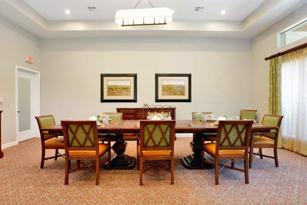 Bright dining area with wooden tables, pendant lights, and decorative shelving, at Sky Vista in Mesa, Arizona