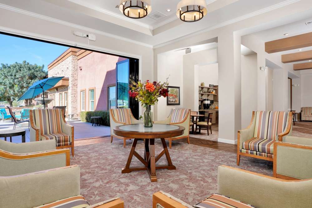 Activity room with tables, chairs, and wall storage cabinets, at Sky Vista in Mesa, Arizona