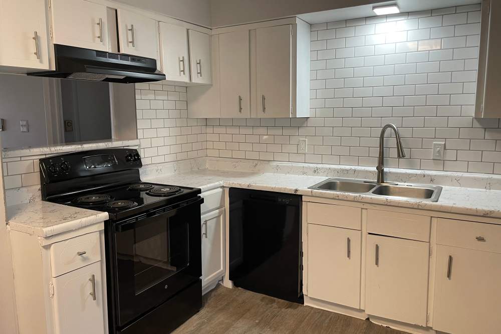 Kitchen with wooden cabinets and a dishwasher at The Sycamores in Indianapolis, Indiana 
