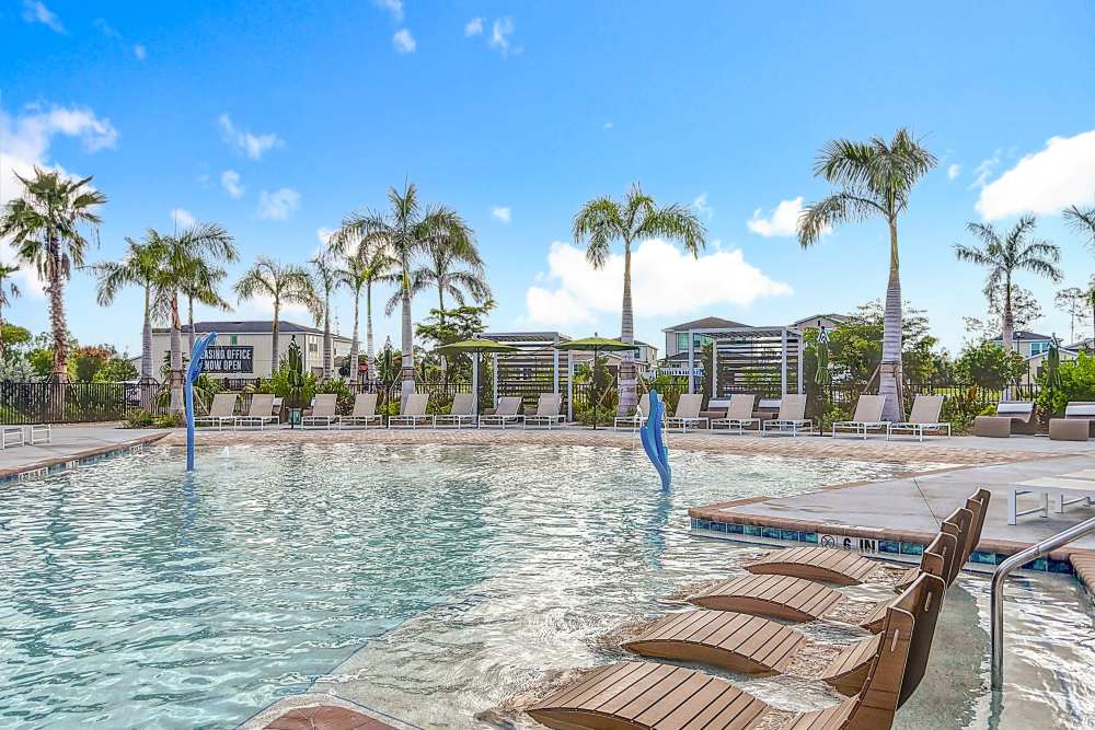 Amenity swimming pool surrounded by trees at BB Living at Lakewood Ranch in Lakewood Ranch, Florida