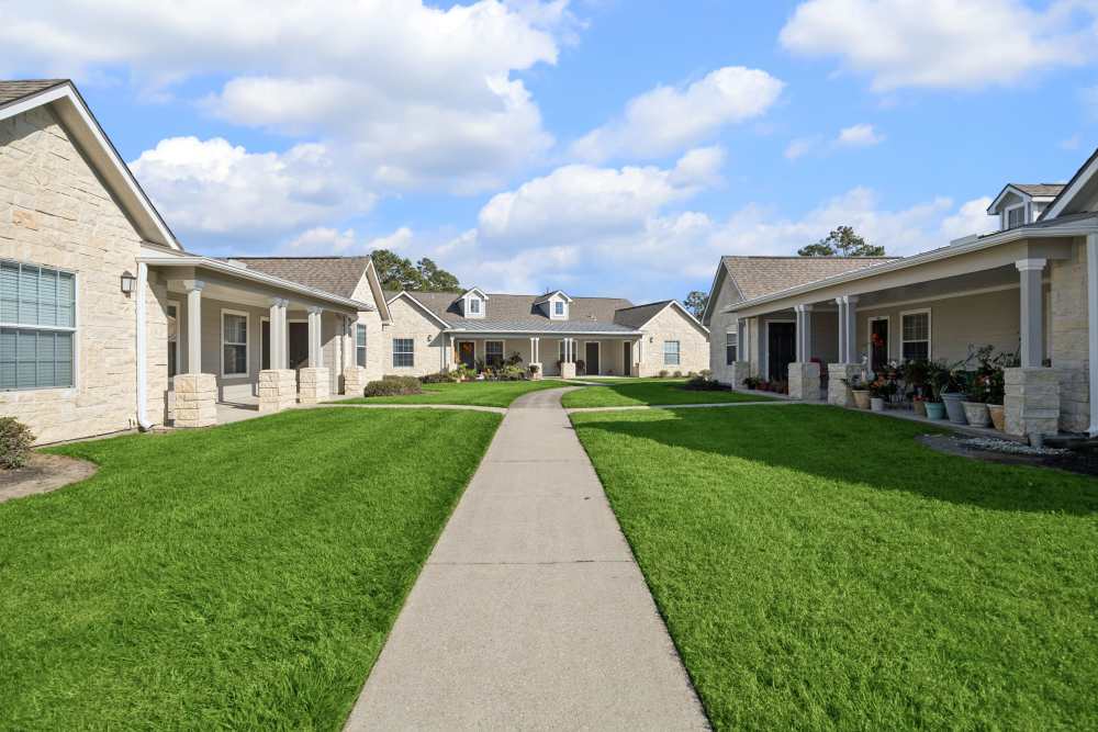 Apartments with walkway and green lawn at Palm Garden in Orange, Texas